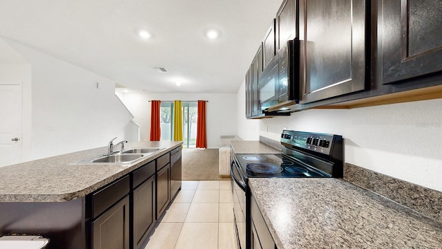 kitchen featuring sink, light tile patterned flooring, black appliances, dark brown cabinetry, and a kitchen island with sink