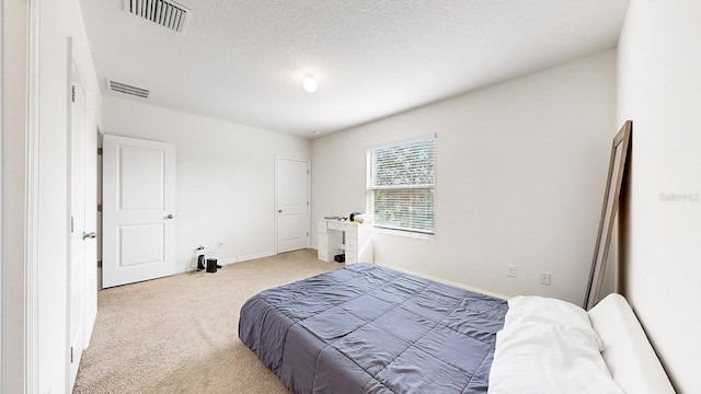 bedroom featuring carpet floors and a textured ceiling