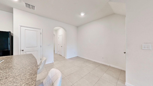 dining space with light tile patterned flooring and lofted ceiling