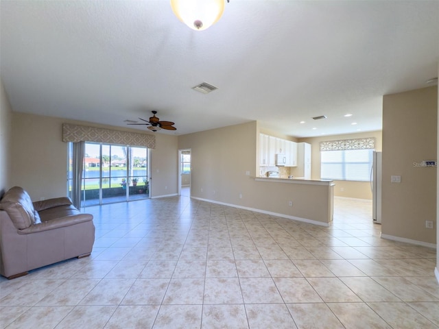 unfurnished living room with ceiling fan and light tile patterned flooring