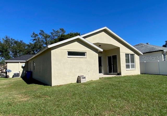 back of house with a lawn