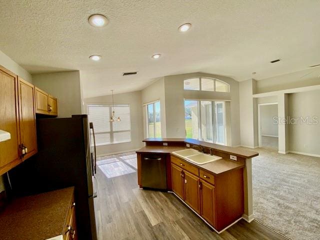 kitchen featuring sink, pendant lighting, wood-type flooring, dishwasher, and lofted ceiling