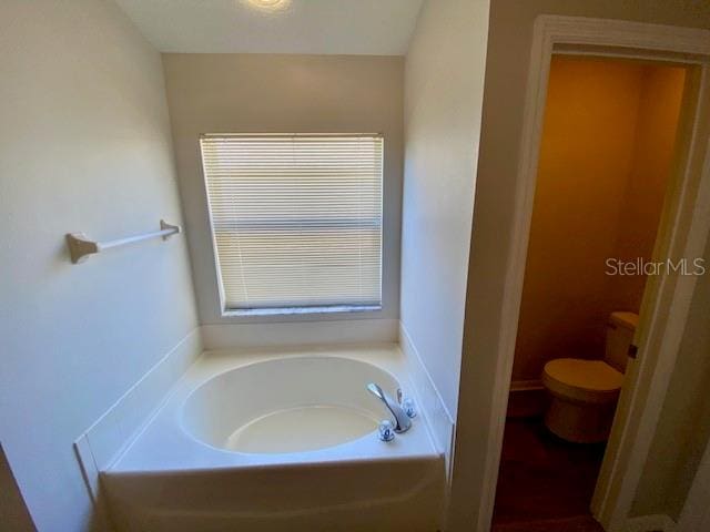 bathroom featuring a washtub and toilet