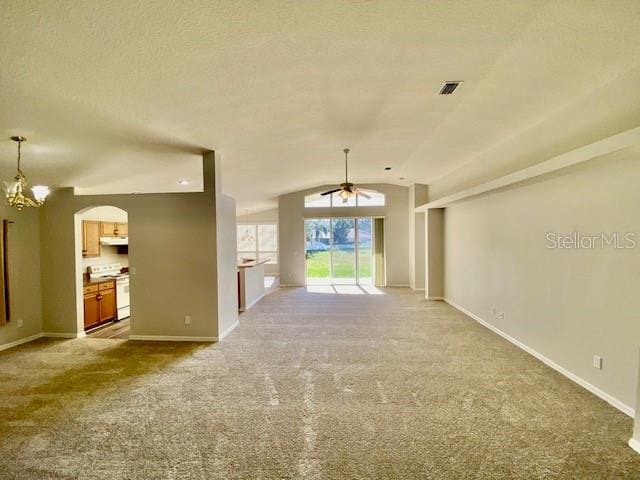 unfurnished living room with ceiling fan with notable chandelier, light colored carpet, and lofted ceiling