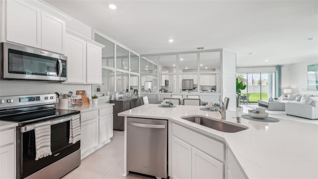 kitchen with sink, white cabinetry, and stainless steel appliances