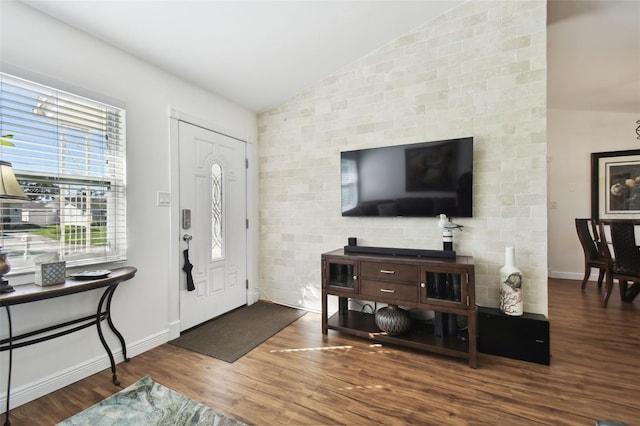 entrance foyer with hardwood / wood-style floors and vaulted ceiling