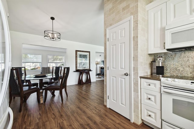 dining area with dark wood-type flooring and a notable chandelier