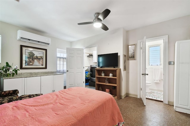 bedroom featuring ceiling fan, a wall unit AC, and connected bathroom