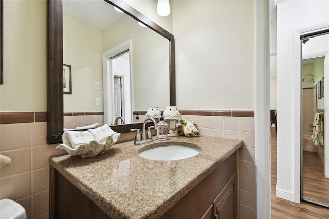 bathroom with vanity, tile walls, and hardwood / wood-style flooring