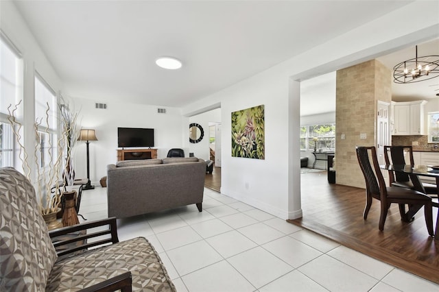 living room with a notable chandelier and light wood-type flooring