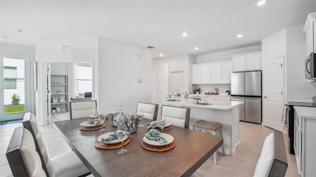 tiled dining room featuring sink