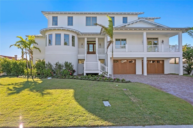 view of front of home with french doors, a front lawn, a porch, and a garage