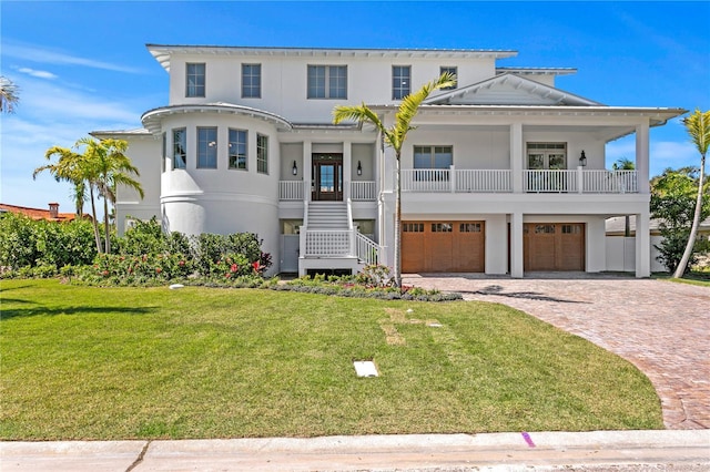 view of front of home featuring driveway, a front yard, stairs, and a garage