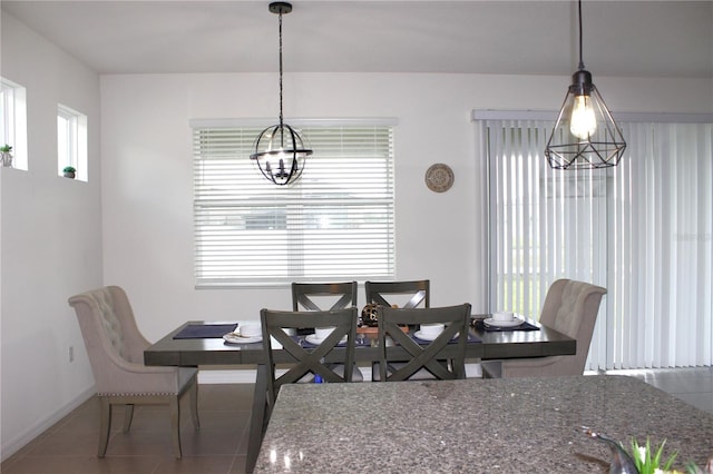 dining space featuring tile patterned flooring and a notable chandelier