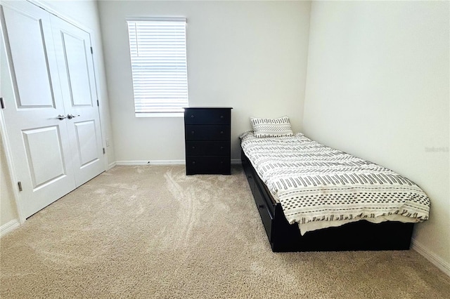 bedroom with a closet and light colored carpet