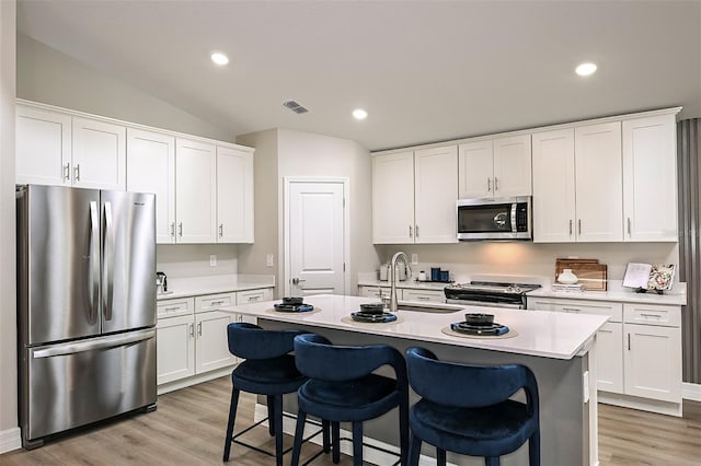 kitchen featuring sink, white cabinetry, a center island with sink, and stainless steel appliances