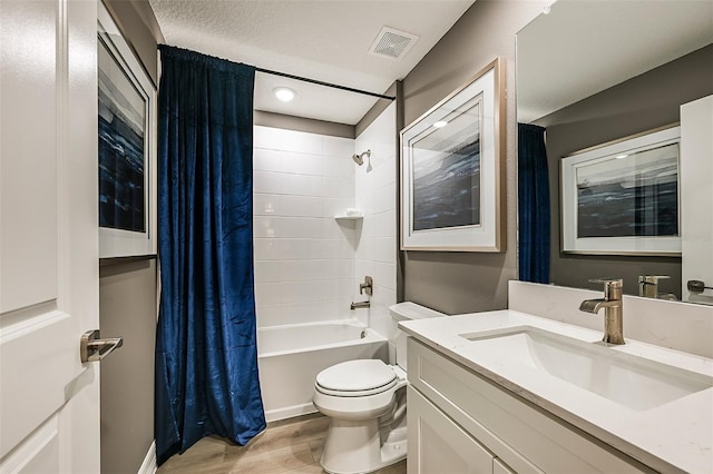 full bathroom featuring toilet, vanity, shower / tub combo, hardwood / wood-style flooring, and a textured ceiling