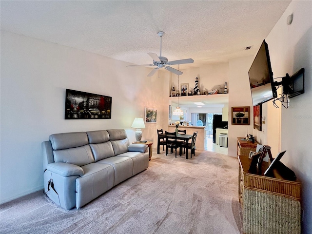 carpeted living room with ceiling fan and a textured ceiling