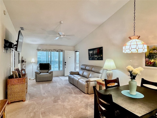 carpeted living room with ceiling fan and high vaulted ceiling