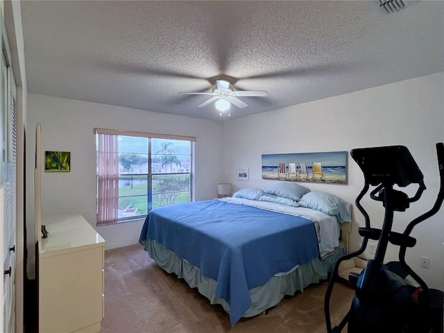 carpeted bedroom with a textured ceiling and ceiling fan