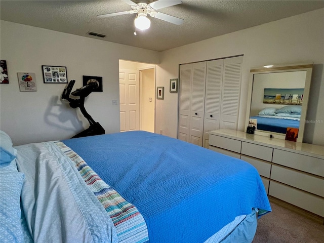 carpeted bedroom featuring ceiling fan, a textured ceiling, and a closet