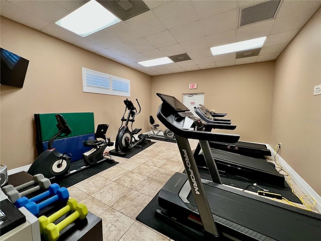 exercise area with tile patterned flooring and a paneled ceiling