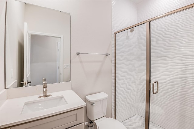 bathroom with toilet, a shower stall, and vanity