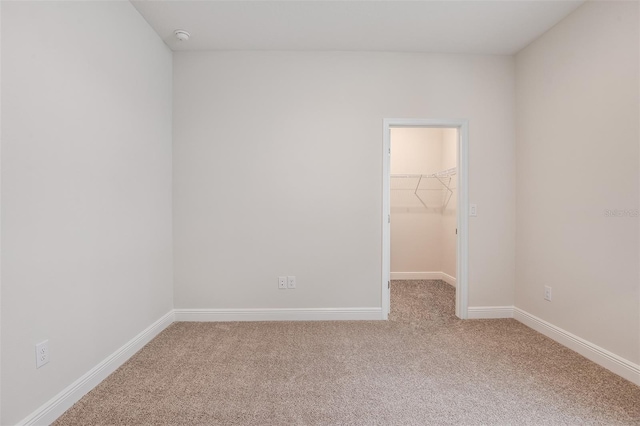 empty room with baseboards and light colored carpet