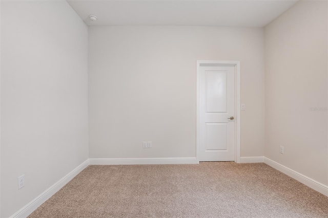 unfurnished room with light carpet and baseboards