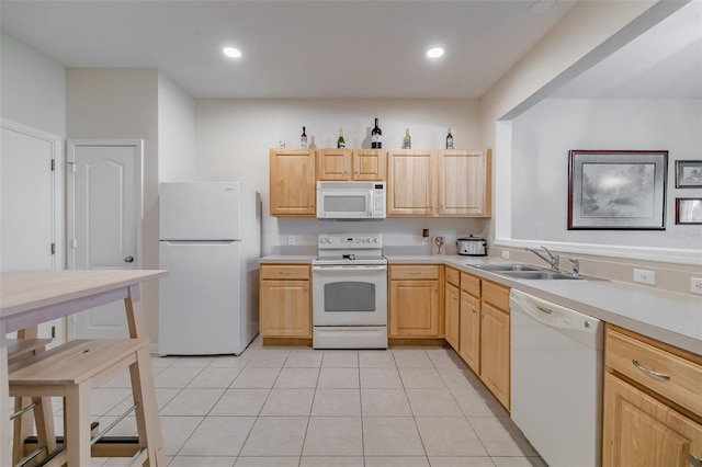 kitchen with light brown cabinetry, sink, light tile patterned floors, and white appliances