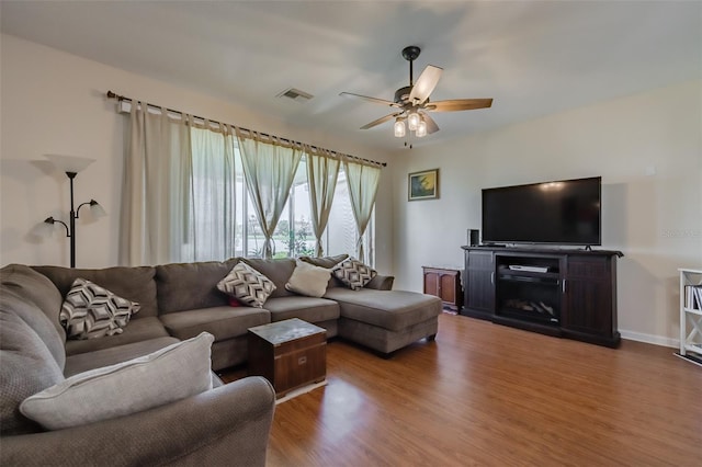 living room featuring hardwood / wood-style floors and ceiling fan