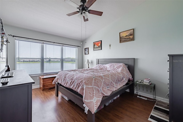 bedroom with lofted ceiling, a water view, ceiling fan, and dark wood-type flooring