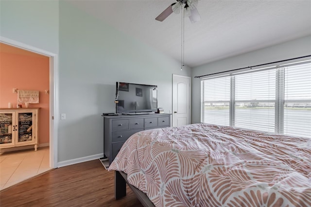 bedroom with a textured ceiling, dark hardwood / wood-style flooring, ceiling fan, and lofted ceiling