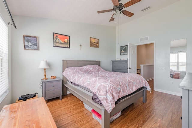 bedroom with ceiling fan, lofted ceiling, and light hardwood / wood-style flooring