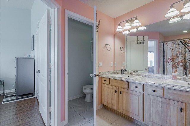 bathroom with hardwood / wood-style flooring, vanity, and toilet