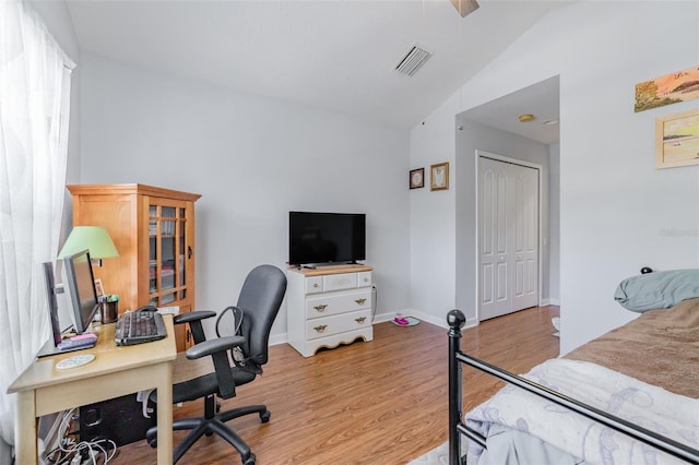 bedroom with vaulted ceiling, light hardwood / wood-style flooring, and a closet