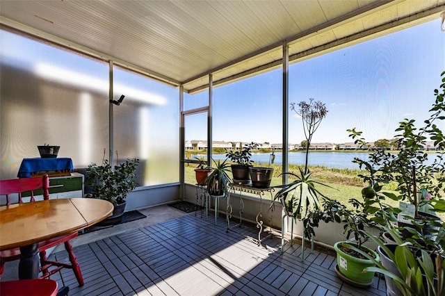 sunroom with a water view and a wealth of natural light