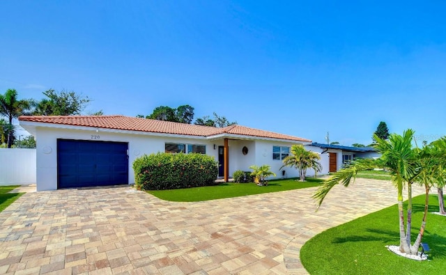 mediterranean / spanish-style house featuring a garage and a front lawn