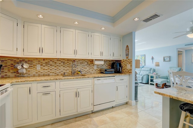 kitchen featuring decorative backsplash, white dishwasher, crown molding, sink, and white cabinets