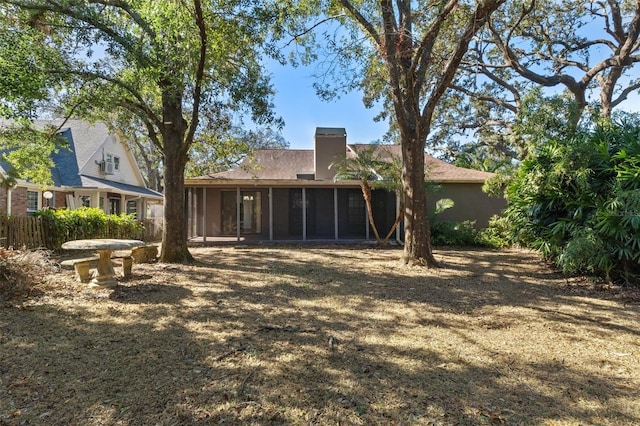 rear view of property featuring a sunroom