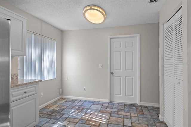 interior space with a textured ceiling and a closet