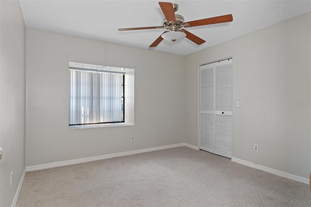 carpeted spare room featuring ceiling fan