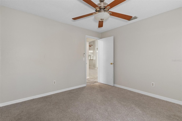 carpeted spare room with ceiling fan and a textured ceiling