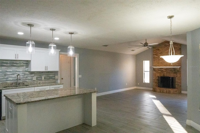 kitchen featuring dark hardwood / wood-style flooring, vaulted ceiling, ceiling fan, sink, and white cabinets