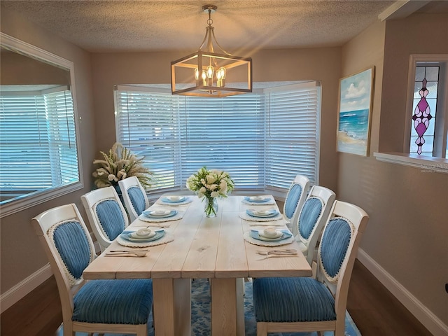 dining area featuring hardwood / wood-style floors, a textured ceiling, and an inviting chandelier