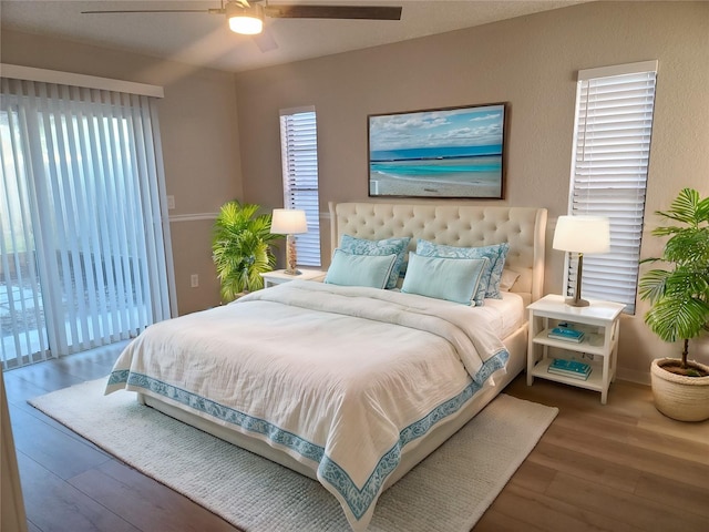 bedroom with ceiling fan, dark hardwood / wood-style flooring, and access to outside