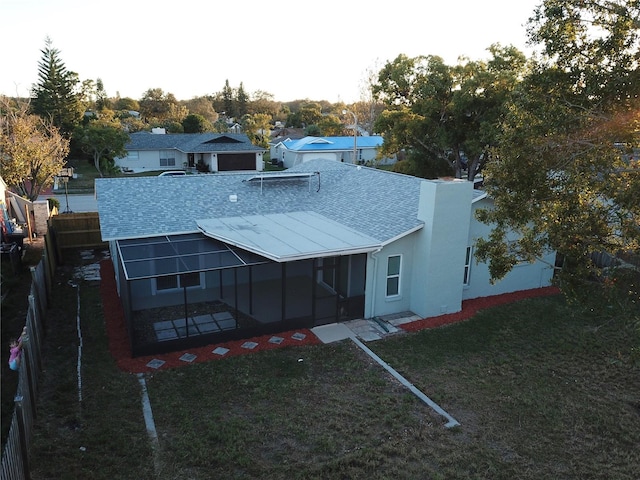 back of property featuring a lawn and a sunroom