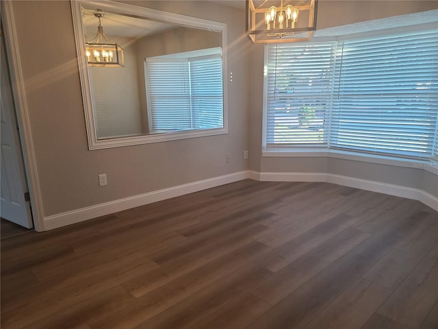 unfurnished dining area featuring dark hardwood / wood-style flooring and an inviting chandelier