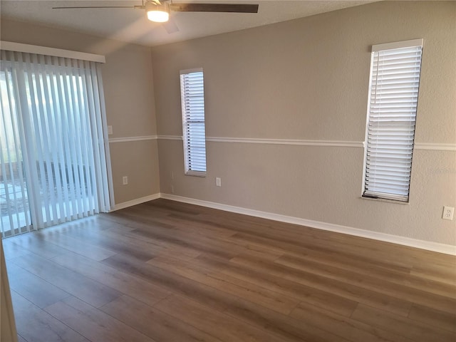 spare room with ceiling fan and dark wood-type flooring