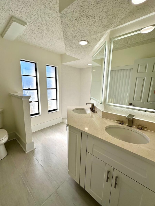 bathroom with vanity, a textured ceiling, and toilet